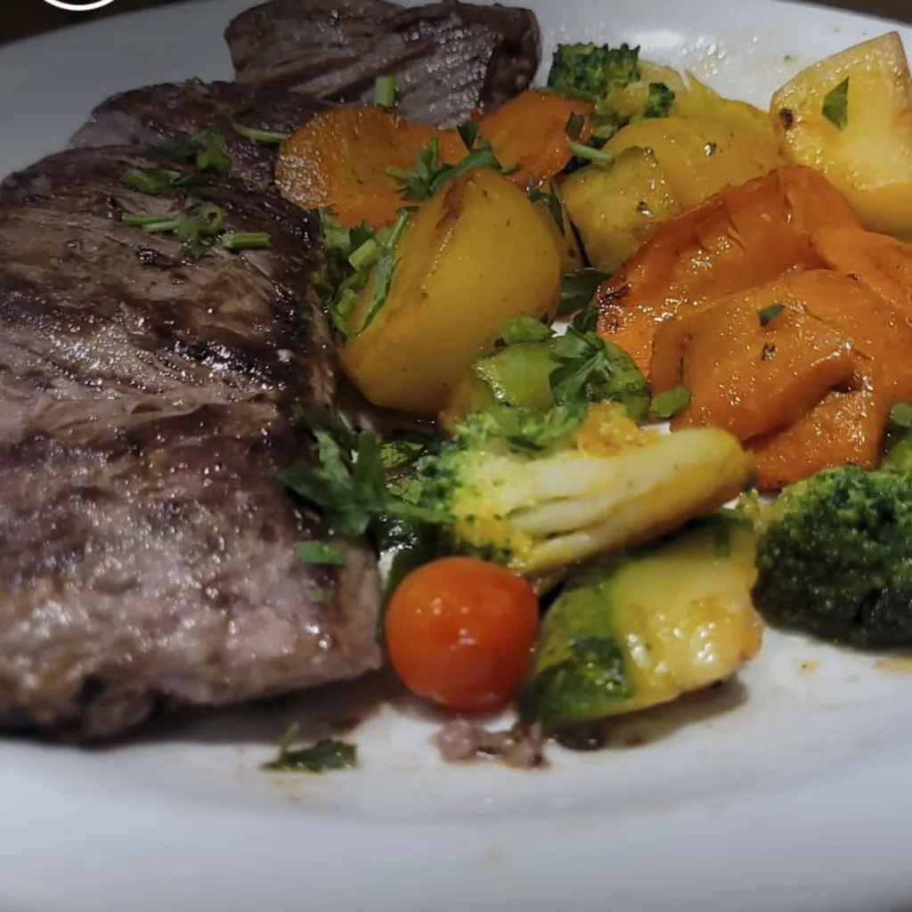 Foto amadora de um prato de bife com legumes tirada no celular